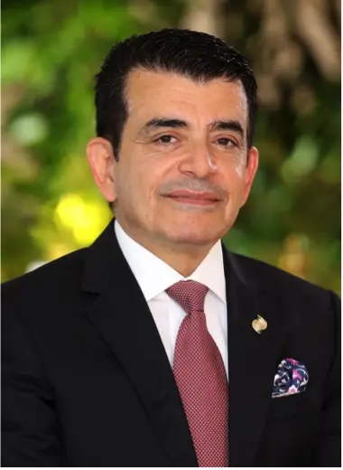 Director General Salim AlMalik wears a dark suit, maroon tie, and ICESCO lapel pin.
